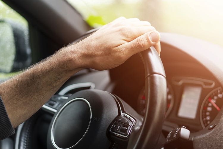 Man holding steering wheel