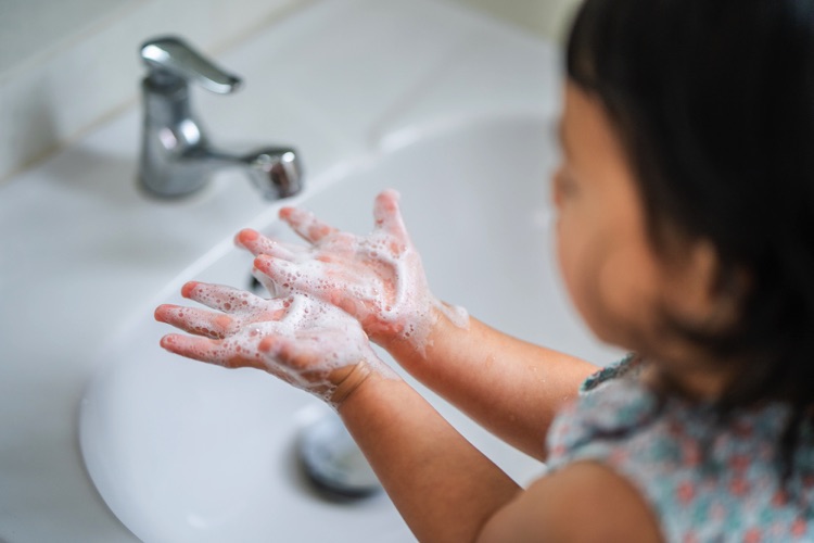 Little girl washing her hands