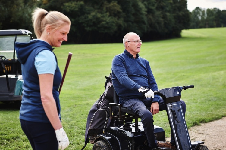Disabled gentleman on golf course in buggy