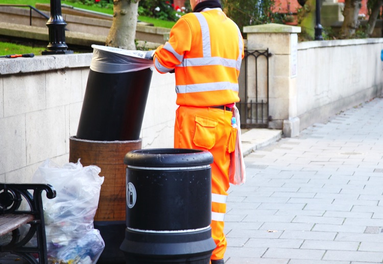 Bin man removing waste from public rubbish bins