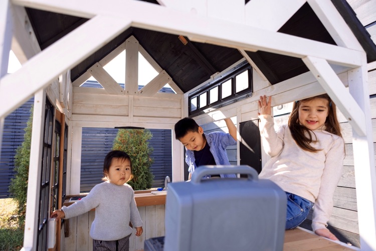 Children playing in outdoor playhouse