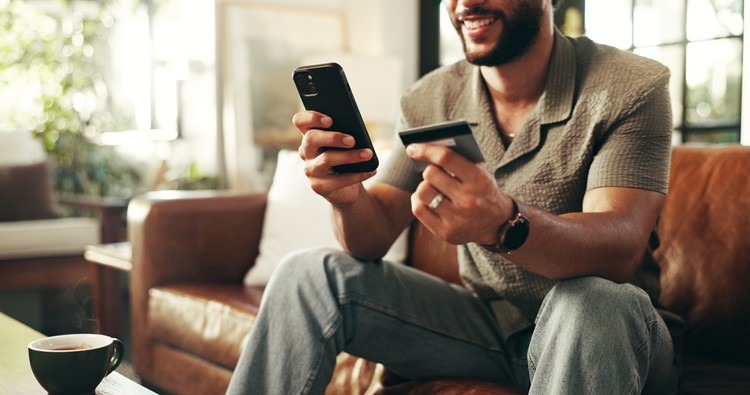 Smiling Man Shopping with Smartphone at Home